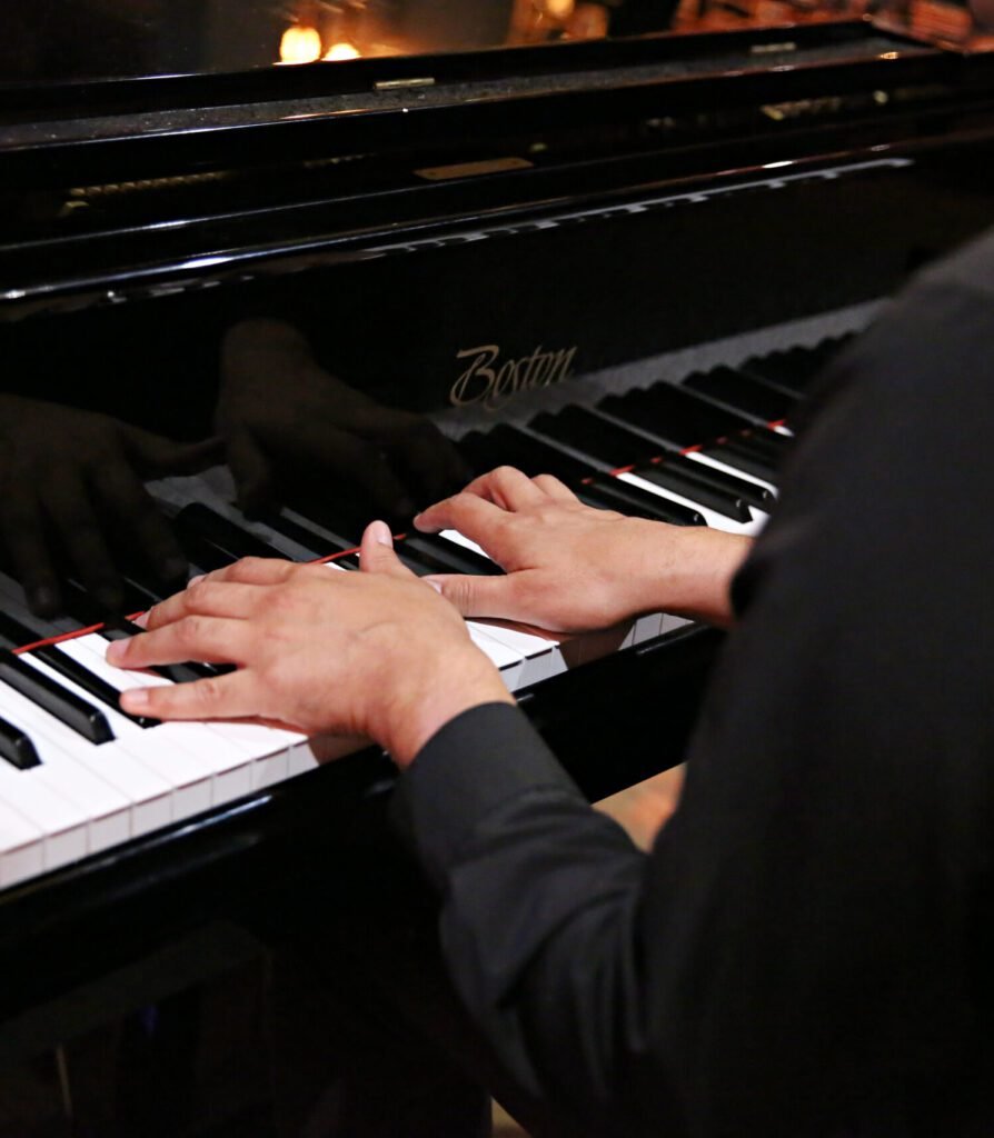 Close-up of hands playing a grand piano